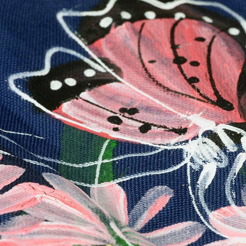 Close-up of a pink flower with green leaves on a navy background