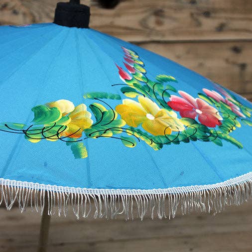 Decorative umbrella with floral design on a wooden surface