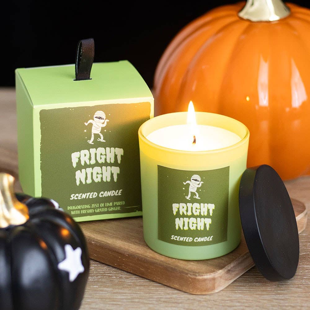 Green 'Fright Night' scented candle with packaging and pumpkins on a wooden surface