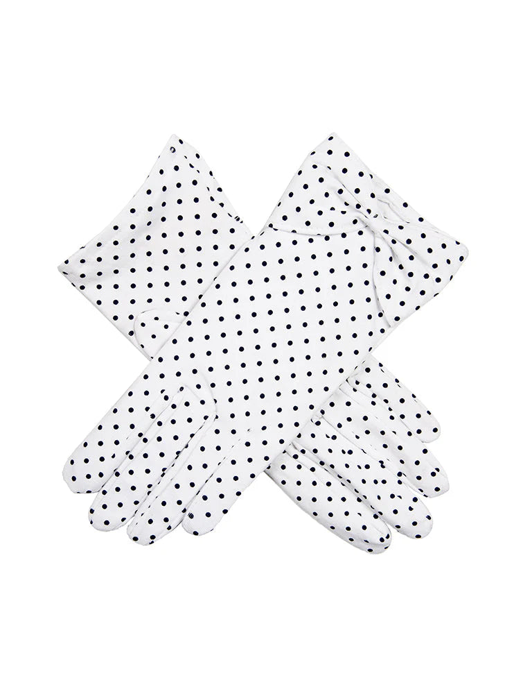 Pair of white gloves with black polka dots on a white background