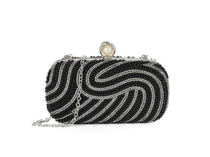 Black beaded clutch with a pearl clasp on a white background