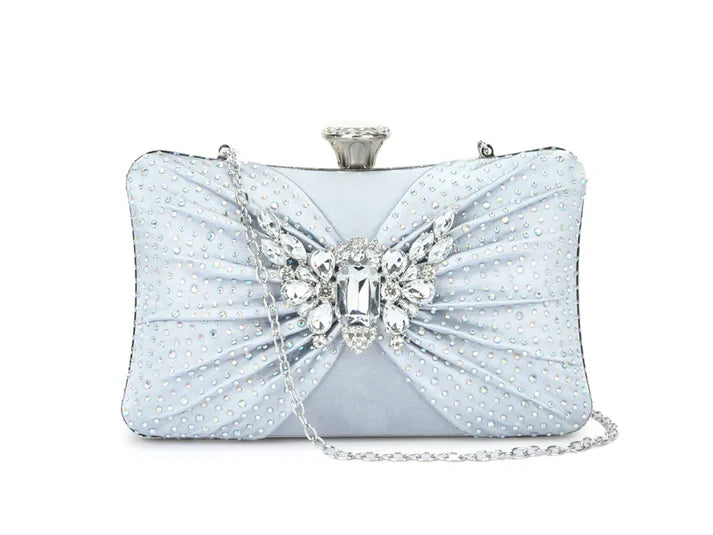Light blue clutch bag with a decorative bow and crystal embellishments on a white background