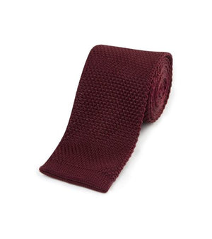 Knitted burgundy tie on a white background